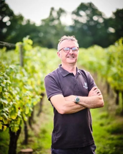 Matt Strugnell, Vineyard Manager standing amongst the vines smiling