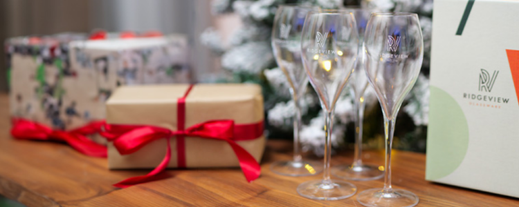 Ridgeview wine glasses with presents infront of Christmas tree